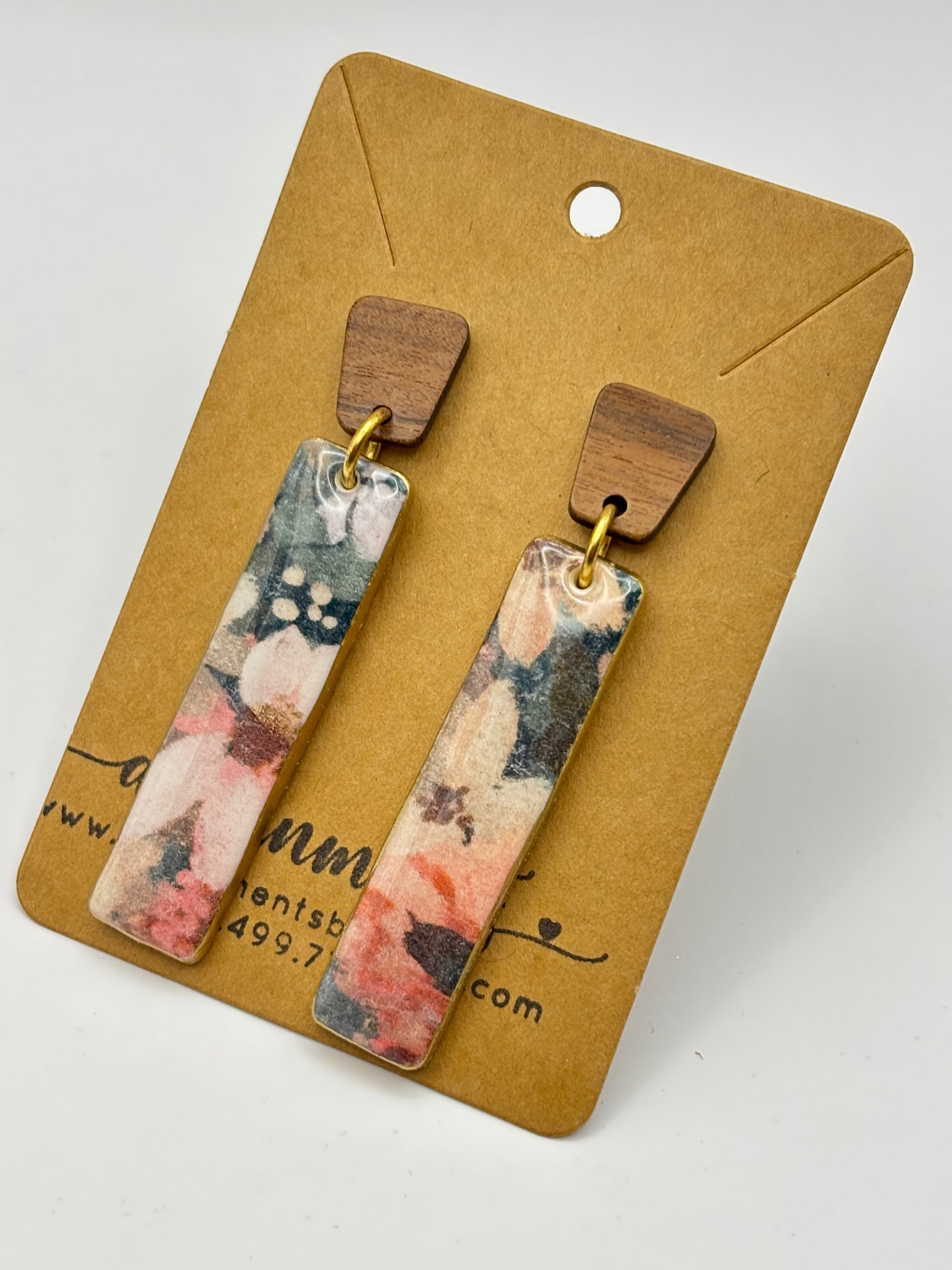 Pair of floral earrings on a brown card with a white background
